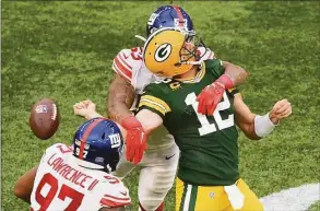  ?? Mike Hewitt / Getty Images ?? The Green Bay Packers’ Aaron Rodgers (12) is sacked by the New York Giants’ Oshane Ximinesand fumbles the ball in the fourth quarter Sunday at Tottenham Hotspur Stadium in London.