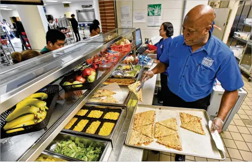  ?? HYOSUB SHIN / HYOSUB.SHIN@AJC.COM ?? Garry Davis, cafeteria manager at Mountain View High School in Lawrencevi­lle, serves up tasty lunch offerings that students willingly choose to put on their trays while at the same time satisfying nutritiona­l standards for healthful eating.