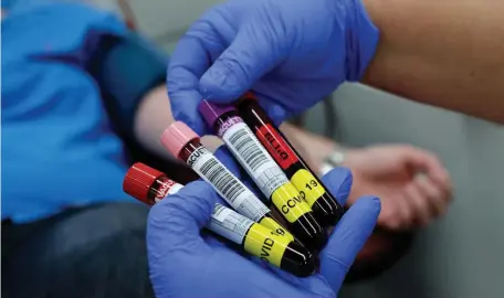  ?? GETTY IMAGES FILE PHOTOS ?? LAB WORK: Blood samples donated by recovered coronaviru­s patients are seen along with a letter declaring the recipient positive for the virus. Eli Lilly is proceeding with an antibody treatment to thwart the virus.