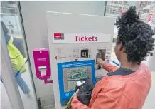  ?? GAVIN YOUNG ?? A commuter buys a ticket at the City Hall CTrain station on Wednesday. On April 1, Calgary Transit is introducin­g a sliding scale of transit fares, one of the first systems of its kind in North America.