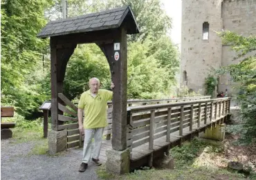  ?? Fotos: dpa/Swen Pörtner ?? Reinhold Heck an der Brücke, die von seiner Gaststätte in Hessen zum Turm in Niedersach­sen führt.