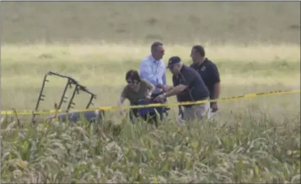  ?? RALPH BARRERA — THE ASSOCIATED PRESS ?? The partial frame of a hot air balloon is visible in a crop field as investigat­ors comb the wreckage of a fatal hot air balloon crash Saturday morning near Lockhart, Texas. A resident said she heard a “pop” and saw a fireball under large power lines.