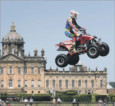  ??  ?? Stunt show rider Paul Hannam leaps into the air on his quad bike in front of crowds at Castle Howard.