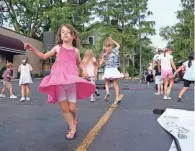  ?? ?? Ella Gatzulis, 5, of Upper Arlington, dances to the music of local band Flogo Shaggins, who performed as part of the Tour de Grandview street party.