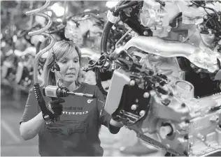  ?? Frank Gunn/The Canadian Press ?? Engine Specialist Jennifer Souch assembles a Camaro engine at the GM factory in Oshawa, Ont.