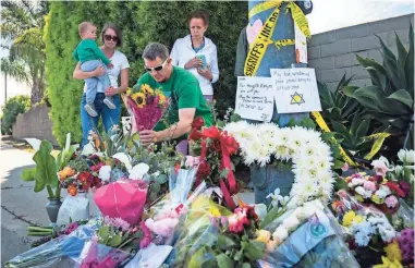  ?? HARRISON HILL/USA TODAY ?? James Carmey of San Diego pays his respects outside the Chabad of Poway synagogue.