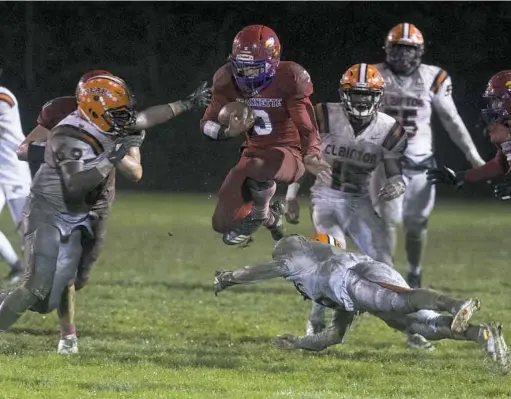  ?? Barry Reeger/ For the Post-Gazette ?? Jeannette running back Imani Sanders hurdles Clairton defender Tyrunne Harvey on a run in the second quarter Friday night at McKee Stadium in Jeannette.