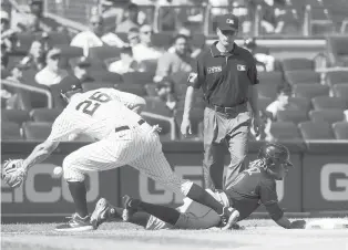  ?? JIM MCISAAC/GETTY ?? The Indians’ Jose Ramirez dives back to third base during the fifth inning ahead of a throw to the Yankees’ DJ LeMahieu on Saturday at Yankee Stadium in New York.