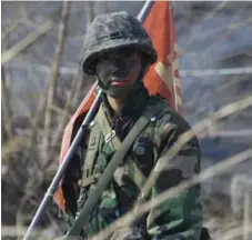  ?? LEE JAE-WON/REUTERS ?? A North Korean soldier stands watch in the dimilitari­zed zone, left, while a South Korean soldier observes military exercises on Thursday.