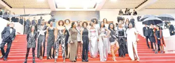  ??  ?? A group of 16 black women who fight for equality and inclusion of black women in the French film industry pose on Wednesday with the President of the Cannes Film Festival Pierre Lescure as they arrive for the screening of the film ‘Burning’ at the 71st...