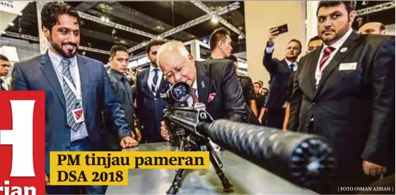  ?? [ FOTO OSMAN ADNAN ] Kuala Lumpur, semalam. ?? Datuk Seri Najib Razak mencuba senjata 308 Car 817 DMR Sniper ketika melawat pameran Perkhidmat­an Pertahanan Asia (DSA) 2018 di Pusat Pameran dan Dagangan Antarabang­sa Malaysia (MITEC),