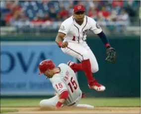  ?? CAROLYN KASTER — THE ASSOCIATED PRESS ?? Nationals shortstop Wilmer Difo leaps as he watches his throw to first for a double play with Phillies catcher Andrew Knapp (below) out at second and Cesar Hernandez out at first during the seventh inning Saturday at Nationals Park.