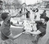  ?? Brett Coomer / Staff photograph­er ?? Volunteers Anthony Nelson, left, and Ivan Sanchez unload water for Fifth Ward residents Feb. 25.