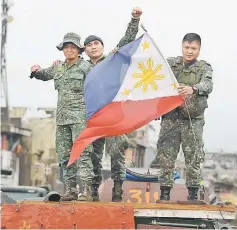  ??  ?? Philippine soldiers aboard their armoured personnel carrier celebrate after Duterte declared Marawi City ‘liberated’, inside the battle area of Bangolo in Marawi. — AFP photo