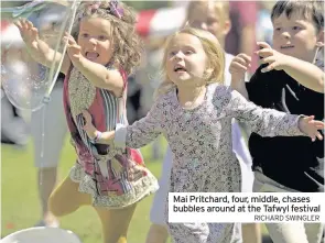  ?? RICHARD SWINGLER ?? Mai Pritchard, four, middle, chases bubbles around at the Tafwyl festival