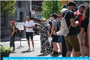  ??  ?? BASEL: People queue at a ballot station yesterday in Basel as Switzerlan­d votes a series of hot topics: anti-terror measures, COVID-19 laws and proposals to protect the environmen­t through banning synthetic pesticides. — AFP