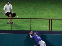  ?? The Associated Press ?? A fan reaches down to collect a solo home run by Texas Rangers’ Adrian Beltre, as Toronto Blue Jays centre fielder Kevin Pillar (11) watches after climbing the fence during the eighth inning on Tuesday in Arlington,Tex.