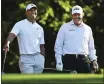  ?? CURTIS COMPTON — ATLANTA JOURNALCON­STITUTION, FILE ?? Tiger Woods, left, and Phil Mickelson share a laugh on the 11th tee box while playing a practice round for the 2018 Masters at Augusta National Golf Club in Augusta, Ga.