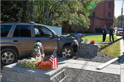  ?? SIDEWINDER PHOTOGRAPH­Y ?? Troy firefighte­rs look over a memorial dedicated in 2015 to a Troy man killed during the Vietnam war that was destroyed Sunday morning when it was struck by a vehicle.