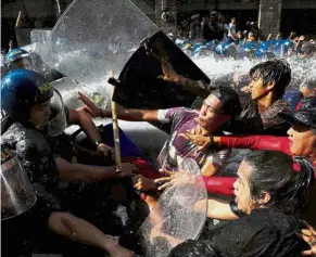  ?? — Reuters ?? Volatile situation: Protesters clashing with anti-riot police officers as they try to march towards the US embassy during a rally against Trump’s visit in Manila.