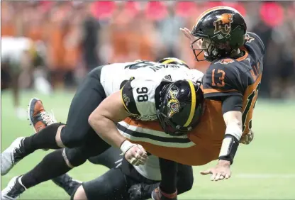  ?? The Canadian Press ?? Hamilton Tiger-Cats’ Dylan Wynn hits B.C. Lions quarterbac­k Mike Reilly as he releases the ball during second-half CFL action in Vancouver on Aug. 24.