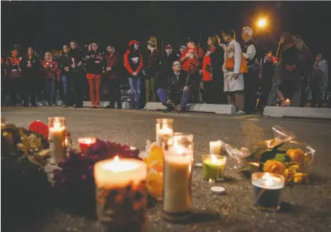 ?? CP PHOTO ?? Mourners gather at a candle light vigil for murdered Stampeders player Mylan Hicks in Calgary on Wednesday.