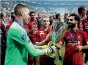  ?? — Reuters ?? SUPER CUP WIN: Liverpool’s Adrian and Mohamed Salah celebrate with the trophy.