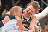  ?? NICOLE SWEET/USA TODAY SPORTS ?? Michigan forward Moritz Wagner, who scored 17 points, celebrates with coach John Beilein after Sunday’s win.