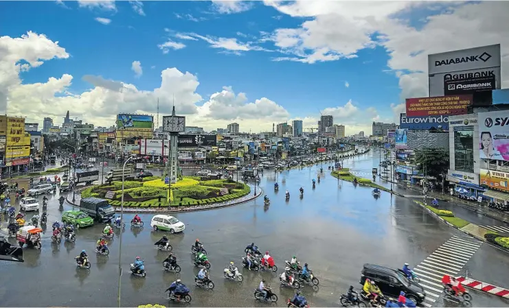  ?? Pictures: GALLO/GETTY ?? THE BUZZ AND THE BREEZE: A busy intersecti­on in Ho Chi Minh City, above; and cyclists near Mai Chau in Vietnam