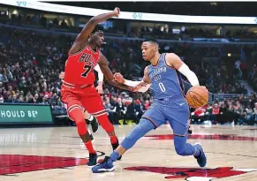  ??  ?? OKLAHOMA CITY THUNDER guard Russell Westbrook dribbles the ball against Chicago Bulls guard Justin Holiday during the first half at the United Center.