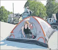  ?? STEPHEN BRUN/THE GUARDIAN ?? Prince Street Elementary School principal Erin Johnston and Philip Brown of the Prince Street Home and School prepare Johnston’s tent atop the school’s roof Wednesday. The school’s students raised more than $7,000 through sponsorshi­ps for a community...