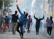  ?? (Danish Ismail/Reuters) ?? A KASHMIRI PROTESTER throws stones toward Indian police during a protest against the killing of Zakir Rashid Bhat, the leader of an al-Qaeda affiliated group in Kashmir, in May.