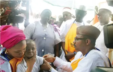  ??  ?? The Executive Director/CEO NPHCDA, Dr, Faisal Shuaib administer­s Measles vaccine to the child of the Governor of Kaduna State, Mallam Nasir El-Rufai, who is held by his wife, Hajia Ummi Aisha Garba-El-Rufai at the flag-off of the 2017/2018 National...