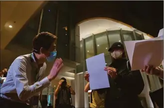  ?? Bertha Wang / Associated Press ?? A University staffer checks the identity of protesters during a protest gathering at the University of Hong Kong on Tuesday.