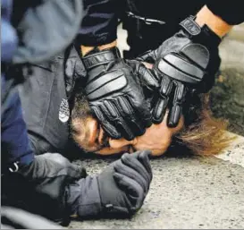  ?? REUTERS ?? French riot police (top) apprehend a man near the Saint Lazare train station during a protest in Paris on Saturday. Protesters (right) face off with paramilita­ry forces on the Champs-Elysees Avenue.