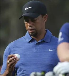  ?? ASSOCIATED PRESS FILE PHOTO ?? In this Feb. 2 photo, Tiger Woods awaits play in the first round at the Dubai Desert Classic. Woods withdrew from the tourney with a back injury after shooting an opening-round 5-over 77.