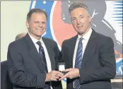  ?? BRUCE BENNETT — GETTY IMAGES ?? Selection committee member Mike Gartner, left, presents a Hall of Fame ring to Doug Wilson.