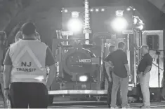  ?? JESSICA REMO, AP ?? Bomb squad personnel stand around the scene of an explosion near a train station early Monday in Elizabeth, N. J.