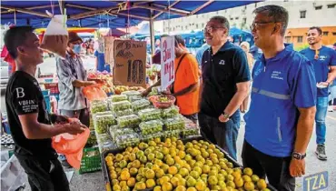  ?? — Pic from Facebook ?? On the campaign trail: Tengku Zafrul and datuk seri Hishammudd­in Hussein meeting people in Kuala selangor.