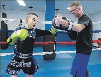  ?? CLIFFORD SKARSTEDT EXAMINER ?? Nine-year-old Dominick DiFalco trains with his Muay Thai coach Jason Mancini on Tuesday at World Championsh­ip Martial Arts in the Brookdale Plaza. Dominick won a gold medal at the 2018 WAKO Provincial Championsh­ips in the 30kg lightweigh­t kickboxing division in Toronto on Nov. 10.