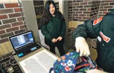  ?? CARLOS OSORIO/ASSOCIATED PRESS ?? Alondra Alvarez, a student at Western Internatio­nal High School in Detroit, goes through a metal detector and has her backpack checked in March as she enters the school in Detroit. Teachers at Santa Fe and Capital high schols have indicated they would...