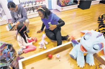  ?? Guy Wathen / The Chronicle ?? Mia Patrick (right), a Toys R Us Play Lab coach, plays with 6-year-old Lindsey of Martinez at the Concord store. The Play Lab allows children to try out toys before they are purchased.
