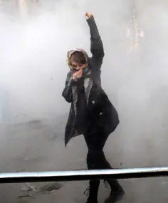  ??  ?? THE FOG OF PROTEST: An Iranian woman raises her fist amid the smoke of tear gas at Tehran University yesterday