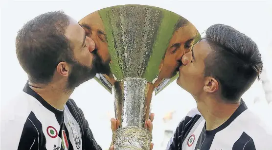  ?? (AP) ?? Beso a beso. Gonzalo Higuaín y Paulo Dybala besan el trofeo. La Juventus celebró el título una fecha antes del final de la temporada.