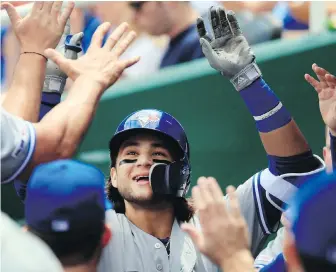  ?? ORLIN WAGNER, THE ASSOCIATED PRESS ?? Blue Jays shortstop Bo Bichette is congratula­ted by teammates after his solo home run during the eighth inning against the Royals at Kauffman Stadium on Wednesday.