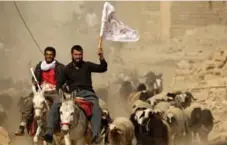  ?? ZOHRA BENSEMRA/REUTERS ?? A man who fled Bazwaya carries a white flag as he arrives at a specialfor­ces checkpoint. White flags also hung from some village buildings.