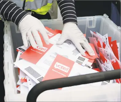  ?? John Froschauer / Associated Press ?? A King County Election worker collect ballots from a drop box in the Washington State primary in Seattle. Washington was a vote by mail state in March.