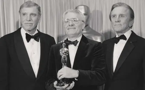  ??  ?? TRIUMPHS: Actors Burt Lancaster (left), and Kirk Douglas (right) stand with Peter Shaffer, winner of the best adapted screenplay Oscar for Amadeus, during the Academy Awards in Los Angeles on March 25, 1985
