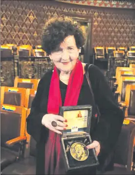  ??  ?? La autora de Coronada de moscas muestra la medalla que recibió ayer en la inauguraci­ón del Festival Internacio­nal Cervantino ■ Foto Carlos García