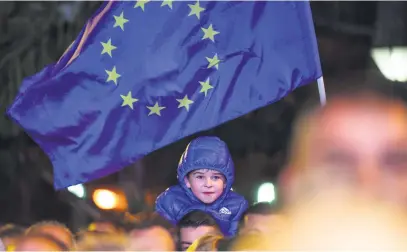  ?? Picture: EPA-EFE ?? HAPPY DAYS. A young boy smiles under the EU flag during a rally supporting the upcoming referendum to endorse a name to end a long-running dispute between Macedonia and Greece.